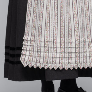 <span style="font-size: 19.2px; line-height: 27.648px;">Man kan bruke flere typer forkle til Fanabunaden. Kulørt forkle var mye brukt store deler av 1800-tallet og i høyeste høytid brukte man det hvite forkleet med heklekanter. Kulørt forkle er et bomullsforkle med blomstertrykk. Bunnen er lys og mønsteret kan variere. </span>