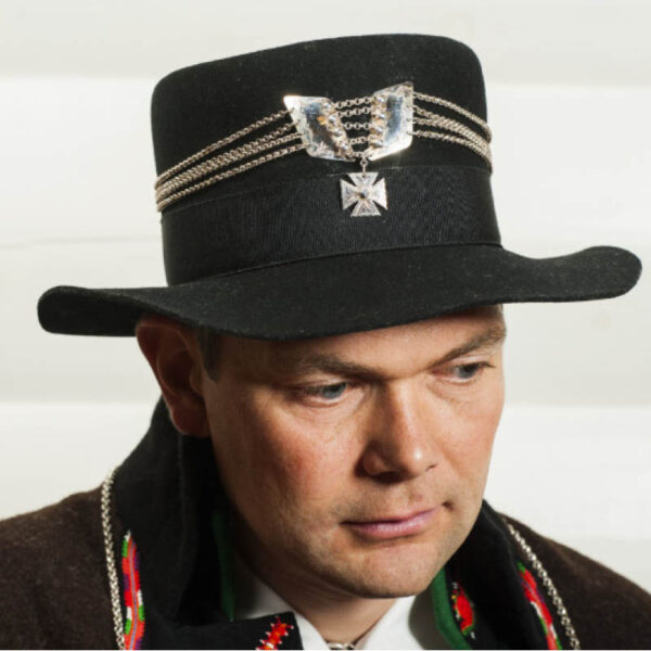 <br>Hatten er ein viktig del av Setesdalsbunaden til herre. Hattane har hatt mange formar gjennom tida.<br> Den kan pyntast med løyesauma band eller hattesylv. Husfliden fører to typer hatter